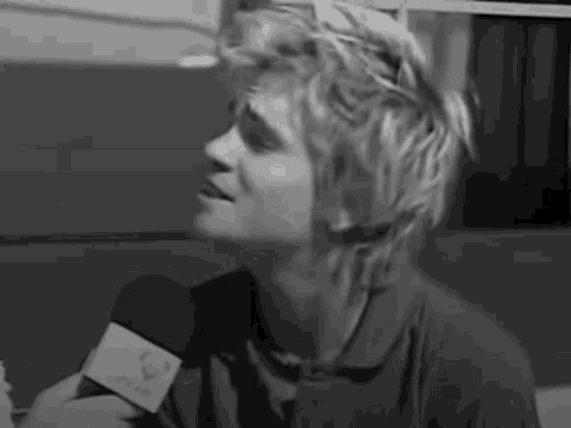 a man is holding a microphone in his hand and talking into it .