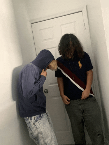 a man wearing a polo shirt with a horse on it stands next to another man
