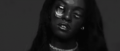a black and white photo of a woman wearing a necklace .