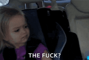 a little girl is sitting in a car seat with the words `` the fuck '' written on her face .