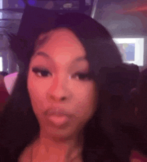 a close up of a woman 's face in a club with a blurred background .