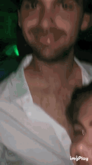 a man in a white shirt is being kissed by a woman