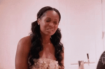 a woman in a wedding dress is standing in a room with a beer tap in the background .