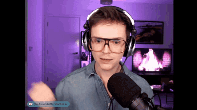 a man wearing headphones and glasses talks into a microphone with a purple background