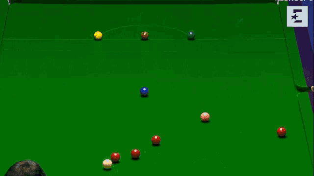 a pool table with a red ball and two yellow balls on it