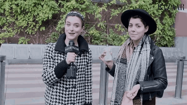 a woman holding a microphone that says harper bazaar