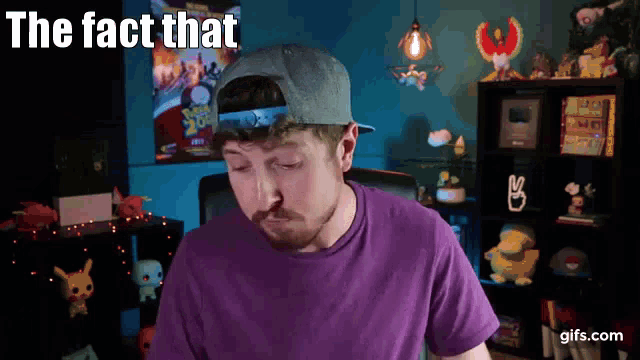 a man wearing a hat and a purple shirt with the words the fact that above him