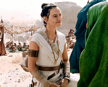 a woman in a white dress is standing in front of a group of people