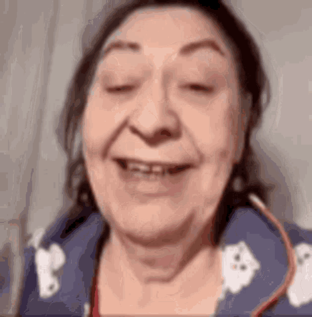 a close up of a woman 's face with her eyes closed and a smile on her face .