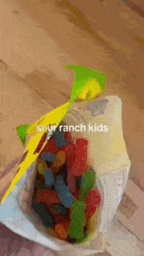 a bag of sour ranch kids gummy bears is on a wooden table .