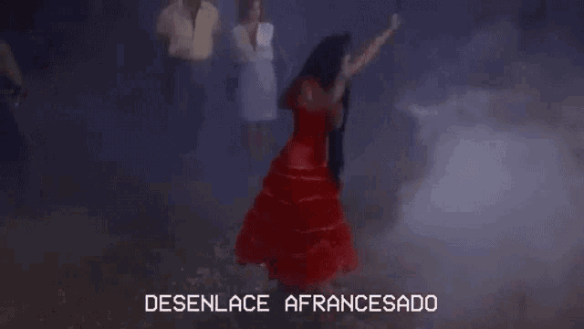 a woman in a red dress is standing in a foggy area and the words desenlace afrancesado are above her
