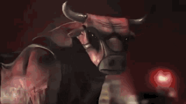 a red bull with horns is standing in a dark room with a red light behind it .