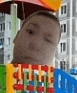 a close up of a person 's face with a blurred background of buildings and toys .