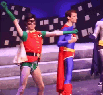a man in a robin costume is standing next to another man in a superman costume