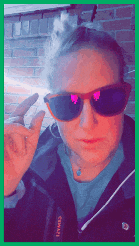 a person wearing sunglasses and a jacket that says genware on the side