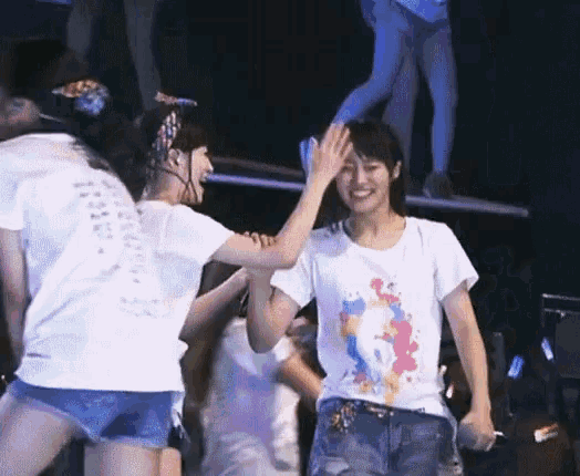 two girls are giving each other a high five while wearing matching shirts