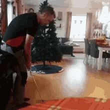 a man is standing in front of a christmas tree
