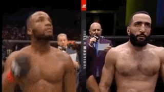 two men are standing next to each other in a boxing ring and one of them has a tattoo on his chest .