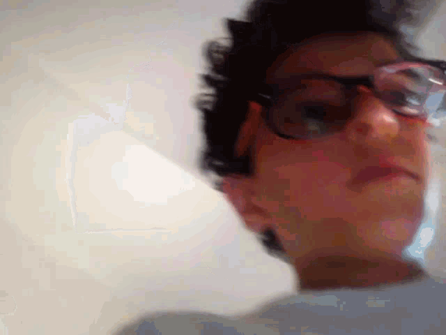 a close up of a person wearing glasses against a white background