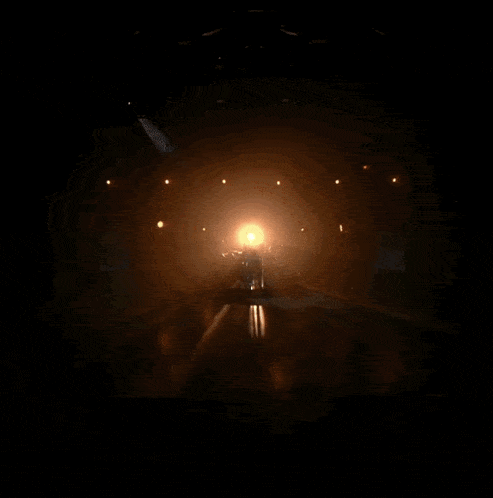 a man is playing a guitar in a dark room