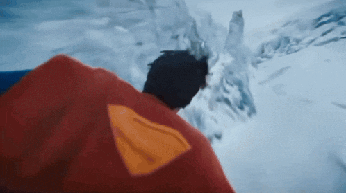 a man in a superman cape is standing in the water