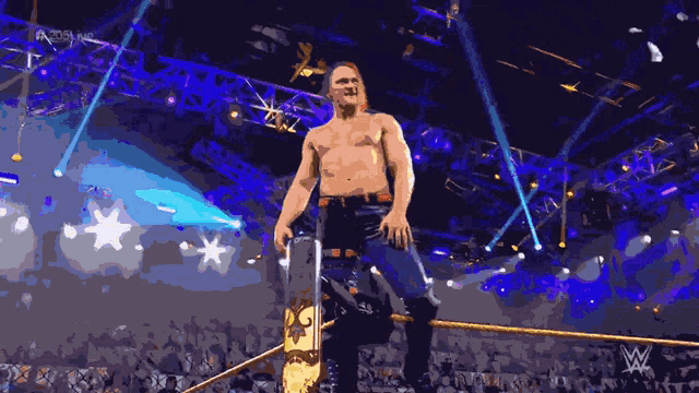 a shirtless wrestler stands in a wrestling ring with the letters w on the bottom