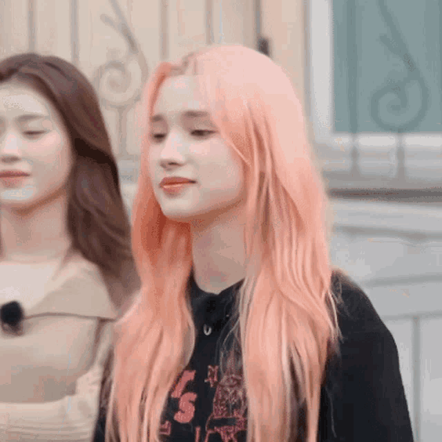 a girl with pink hair is wearing a black shirt that says 5