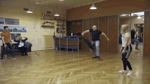 a group of people are dancing in a room with trophies on the walls