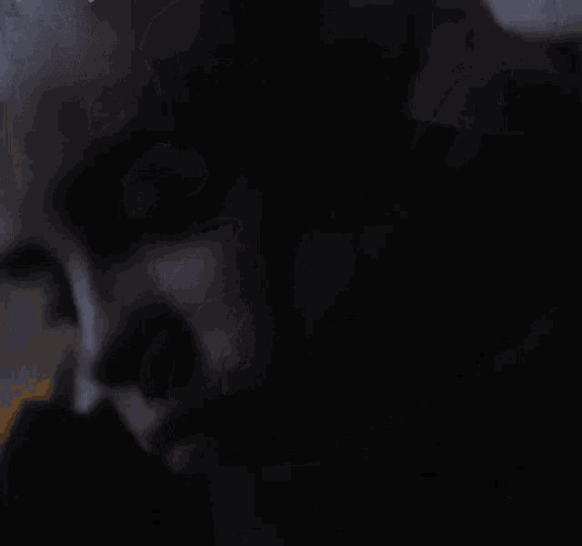 a close up of a person 's face in a dark room .