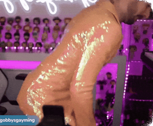a man is dancing in front of a sign that says ' gobbysgayming '