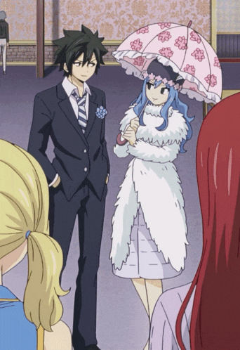 a man in a suit and tie stands next to a woman in a fur coat holding an umbrella