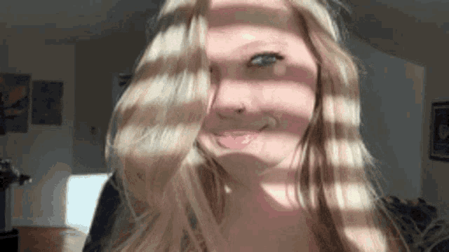 a woman with blonde hair and a nose ring looks at the camera