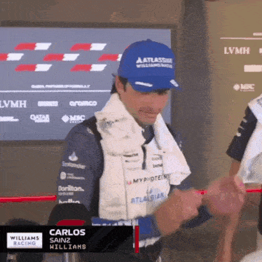 a man wearing a hat that says atlassian williams racing on it