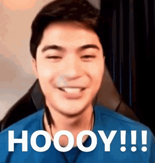 a man is sitting in a chair with his eyes closed and smiling with the word hoooy written on the screen .