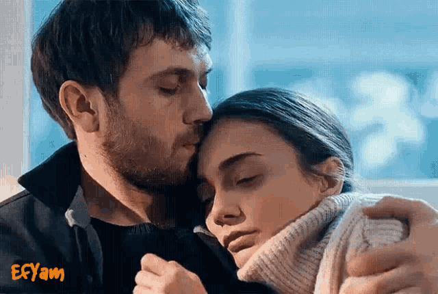 a man kisses a woman on the forehead with the word ebyam written on the bottom