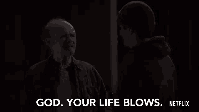 a man and a boy are standing next to each other in a dark room and talking .