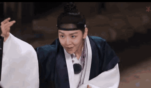 a woman in a traditional costume is dancing with a man in a kimono .