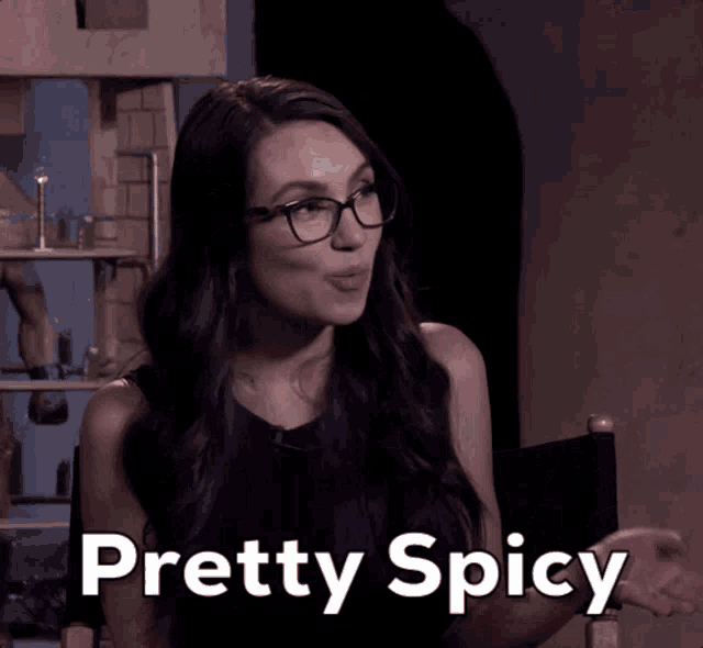 a woman with glasses says " pretty spicy " in a dark room