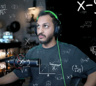 a man wearing headphones and a mclaren shirt stands in front of a blackboard with math equations written on it
