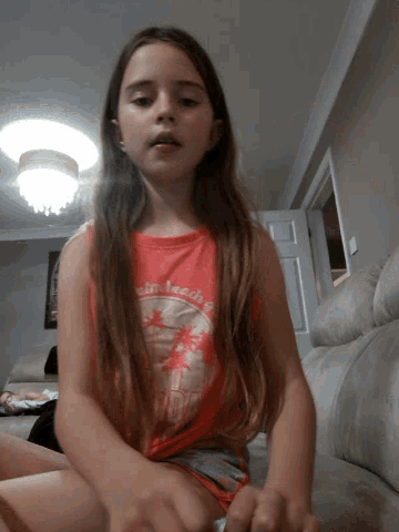 a girl with long hair is wearing a red shirt that says ' beach ' on it
