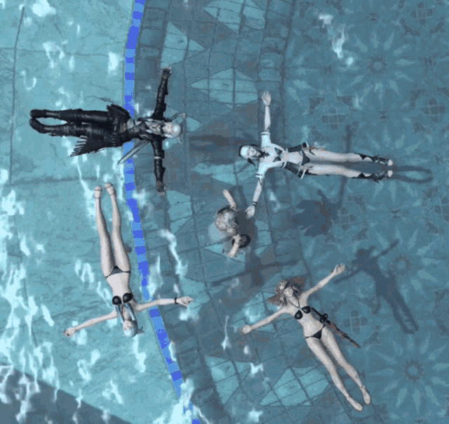 four women in bikinis are floating in a pool with their arms outstretched