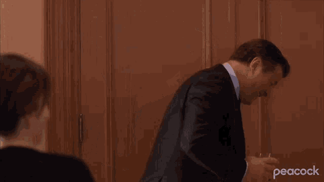 a man in a suit and tie is talking to a woman and saying fire her
