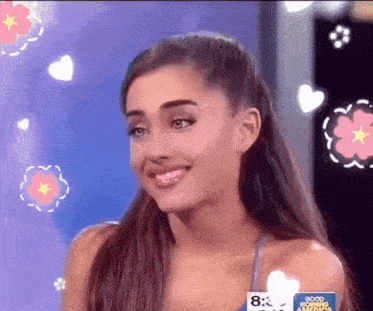 ariana grande is smiling and wearing a blue tank top with the number 8 on it