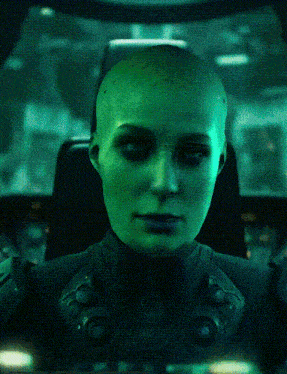 a woman with a shaved head has a green face