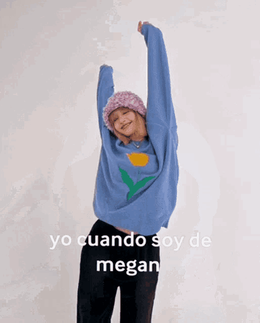 a woman wearing a blue sweater and a purple hat with the words yo cuando soy de megan