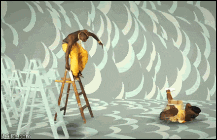 a man is standing on a ladder in front of a wall that says 4gifs.com on the bottom