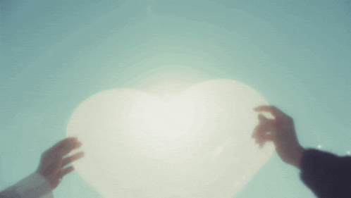 a person holding a white heart shaped object in their hands