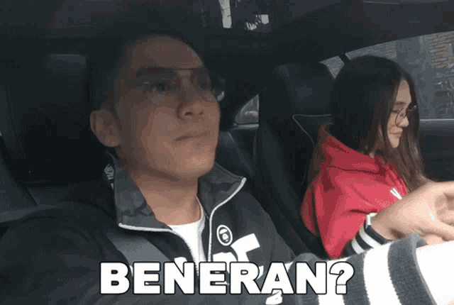 a man and a woman are in a car and the man is wearing glasses