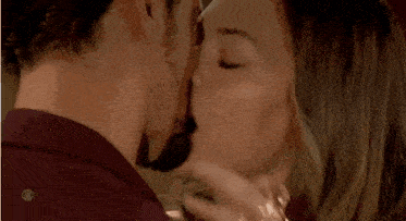 a man and a woman are kissing and the woman is wearing a ring .