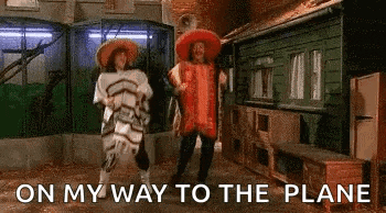two men in sombrero shirts are dancing in a room with the words `` on my way to the plane '' written above them .